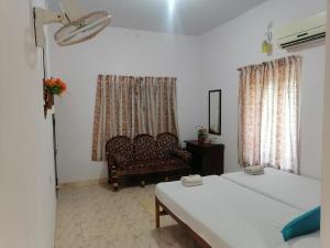sala de estar con 2 camas y sofá en Basuri Beach Resort, en Varkala