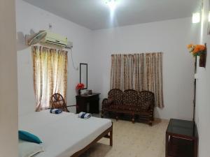 sala de estar con 2 camas y sofá en Basuri Beach Resort, en Varkala