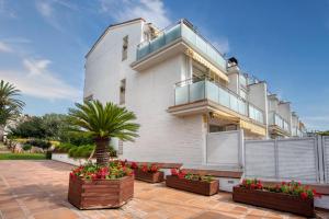 um edifício branco com uma varanda e algumas flores em Big Villa Sagaró em S'agaró