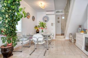 a dining room with a table and chairs and a plant at Big Villa Sagaró in S'Agaro