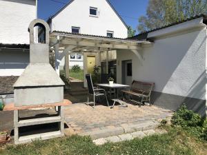 um pátio com um grelhador e uma mesa numa casa em Ferienwohnung Marienhof Erdgeschoss em Seelbach