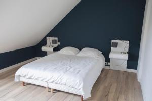 1 dormitorio con 1 cama blanca y paredes azules en Appartement de 60m2 à 2 pas du port de Paimpol, en Paimpol