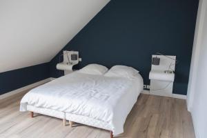 Un dormitorio con una cama blanca y paredes azules. en Appartement de 60m2 à 2 pas du port de Paimpol, en Paimpol