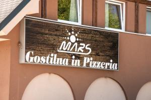 a sign for a restaurant on the side of a building at Guesthouse Mars in Ig +25 photos
