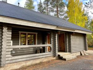 a log cabin with a porch and a window at Taikalevi Apartment in Levi