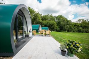 a tiny house with a patio in a yard at Kinelarty Luxury Glamping Pods Downpatrick in Downpatrick