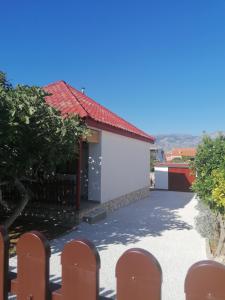 un pequeño edificio blanco con techo rojo en Kuća za odmor Ana, en Ražanac