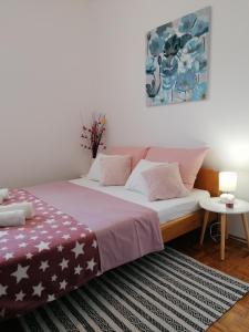 1 dormitorio con 1 cama grande con almohadas rosas y blancas en Kuća za odmor Ana, en Ražanac