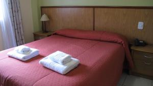 a bedroom with two towels on a bed at Hotel Internacional in San Carlos de Bariloche