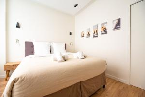 een witte slaapkamer met een groot bed met witte kussens bij MBM - TERRAGE in Parijs