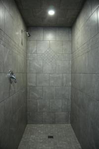 een badkamer met een douche en een tegelvloer bij CARLETON INN & COTTAGES in Bridgetown