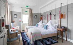 a bedroom with two beds and a chair at The Swan Hotel in Southwold