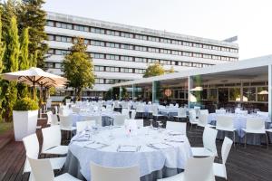 a marquee with white tables and chairs and a building at Living Place Hotel in Villanova