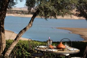 a picnic table with a view of a body of water at Le Petit Hôtel du Flouka in Lalla Takerkoust