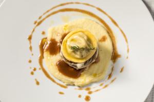 a plate of food with a banana and sauce at Living Place Hotel in Villanova