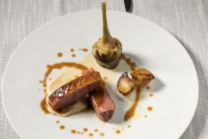 a white plate with some food on a table at Living Place Hotel in Villanova