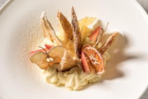 a white plate with a dessert with fruit on it at Living Place Hotel in Villanova
