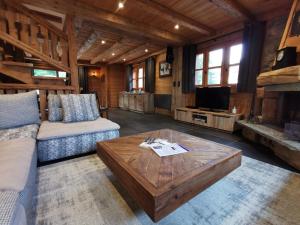 a living room with a couch and a coffee table at Chalet Jardin d'Angèle Chambres d'hôtes in Courchevel