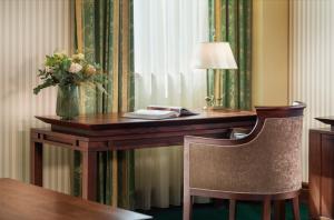 a hotel desk with a vase of flowers on it at Grand Hotel Sofia - Top Location, The Most Spacious Rooms in the City, Secured Underground Parking in Sofia