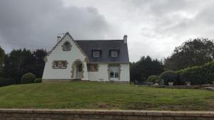 uma casa branca no topo de um campo verde em Chambre d'hote Les Iles Concarneau em Concarneau