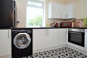 cocina con lavadora y ventana en Nursery Cottage Benmore, en Benmore