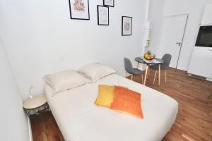 un sofá blanco con 2 almohadas en una habitación en Napoléon Gare 5 STUDIO 1er Etage ByLocly, en Pontivy