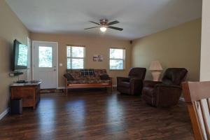 sala de estar con sillas y ventilador de techo en Whispering Pines in the Country on 40 Acres, en Hartville