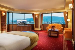 ein Hotelzimmer mit einem Bett und einem großen Fenster in der Unterkunft Grand Hotel Sofia in Sofia