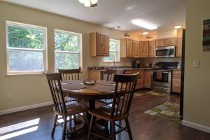 una cocina con mesa de madera y sillas. en Whispering Pines in the Country on 40 Acres, en Hartville