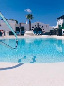 una piscina de agua azul frente a un edificio en HOTEL-FINCA Rural José Manuel 28pax en San Bartolomé