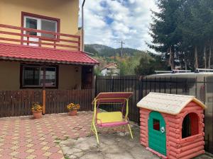 a house and a chair and a dog house at Vila Andra in Azuga
