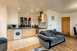 a living room with a couch and a kitchen at Lever St Central in Manchester