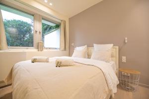 um quarto com uma grande cama branca e uma janela em MBM - LA TOUR em Paris