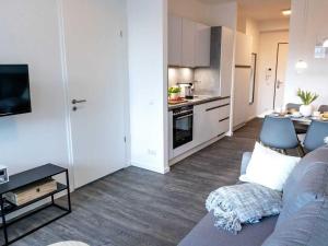 ein Wohnzimmer mit einem Sofa und einer Küche in der Unterkunft Hafenspitze App. 09 in Wismar