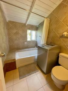 a bathroom with a tub and a toilet and a sink at bungalow 3116 vue sur piscine in Las Galeras