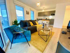 a living room with a couch and a table at Presqu'île de Caen, Terrasse & Parking in Caen +9 photos