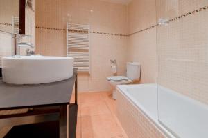 a bathroom with a sink and a toilet and a tub at Pierre & Vacances Aparthotel La Tulipa in Ordino