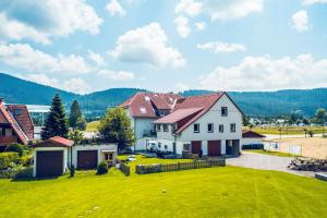 a large white house with a yard with green grass at MINAROSO appartements am badeparadies in Titisee-Neustadt