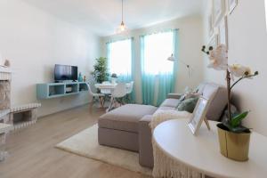 a living room with a couch and a table at Casa da Nespereira - City Centre Duplex Apt with Balcony in Viana do Castelo