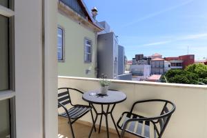 a small table and chairs on a balcony at Casa da Nespereira - City Centre Duplex Apt with Balcony in Viana do Castelo