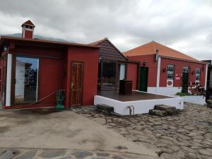 a red house with a bench in front of it at Casa Eremia in Garafía