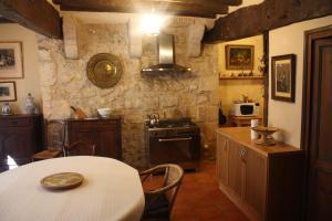 a kitchen with a table and a stove top oven at L' Ancien Relais de Poste Henri in Casteljaloux