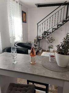 Habitación con mesa, botella de vino y copas en Dreams Apartments, en Niš