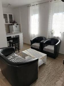 sala de estar con 2 sillas y mesa en Dreams Apartments, en Niš