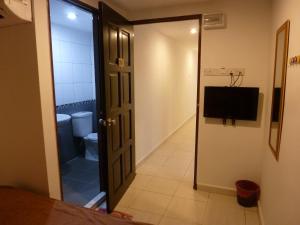 a bathroom with a toilet and a television in a room at RELAX HOTEL in Sungai Petani