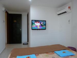 a room with a bed and a tv on the wall at RELAX HOTEL in Sungai Petani