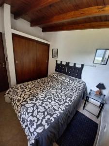 a bedroom with a black and white bed and a table at Lo de Ely in Tafí del Valle