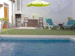 una piscina con due sedie e un ombrellone di Casa Samuel a Granadilla de Abona