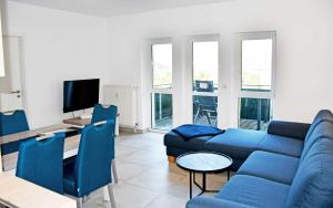a living room with a blue couch and chairs at Hoeft Residenz Alt Reddevitz in Alt Reddevitz