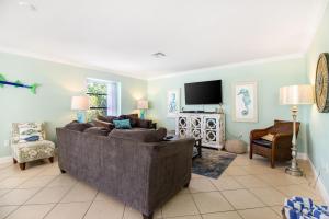 a living room with a couch and a tv at LaRaya Retreat in Anna Maria